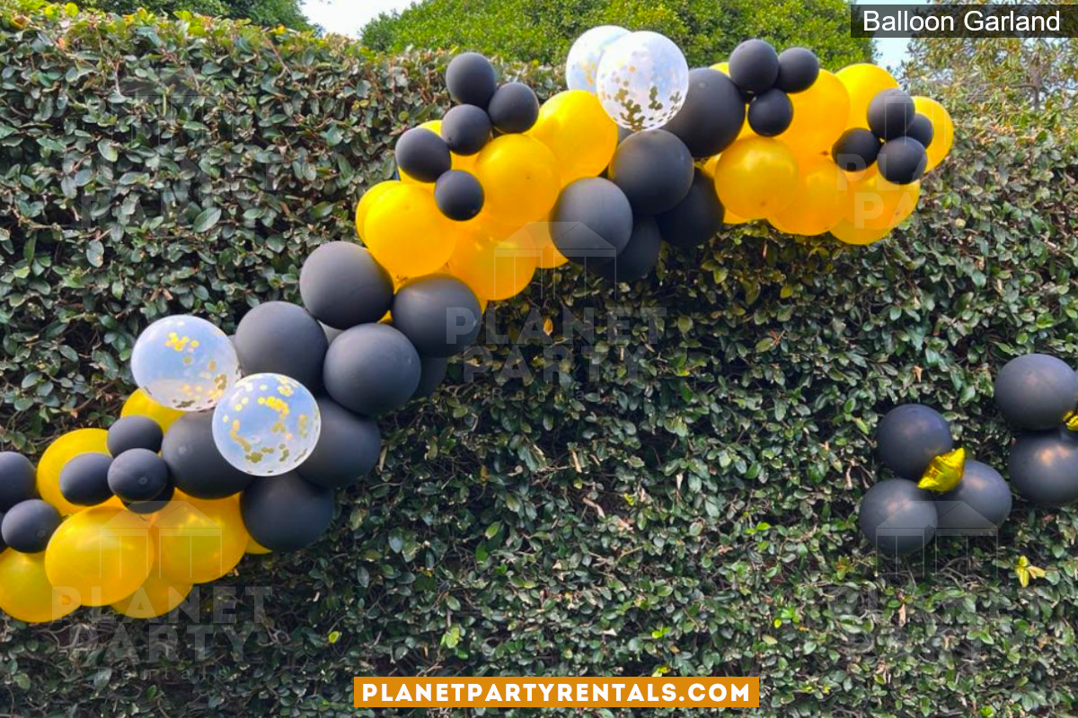 Balloon Garland on hedge with Black White and Yellow Balloons