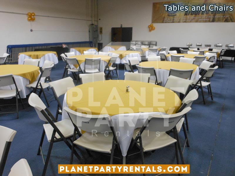 White plastic chairs with round table with white table cloth and yellow overlay/diamond