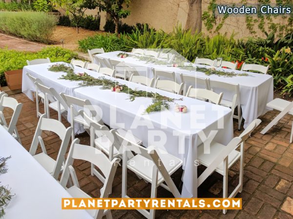 White Wooden Chairs with White Rectangular Tablecloths and Flower Decorations for Wedding Event