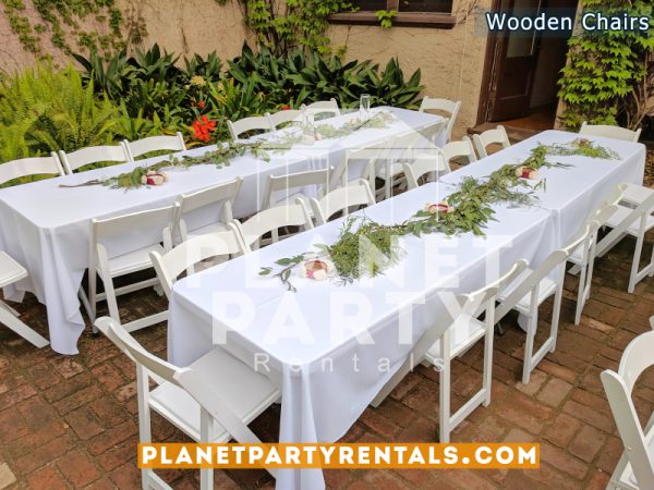 White Wooden Chairs with White Rectangular Tablecloths and Flower Decorations for Wedding Event White Wooden Chairs with White Rectangular Tablecloths and Flower Decorations for Wedding Event